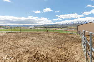 View of yard with a mountain view, a view of countryside, and an outdoor riding arena