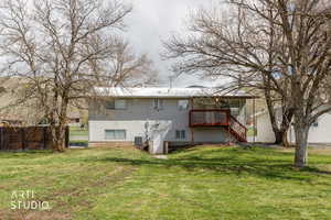 Rear view of property featuring a deck and stairway