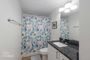 Full bath featuring vanity, light wood-type flooring, and shower / bath combo with shower curtain