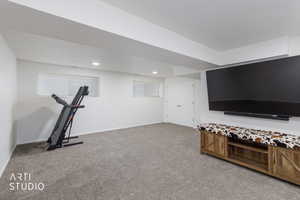 Workout room featuring light colored carpet and baseboards