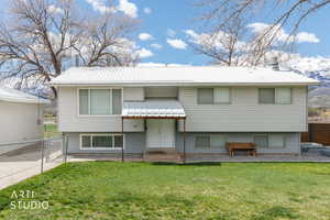 Bi-level home with a gate and a metal roof