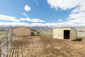 View of yard featuring a mountain view, an outbuilding, a view of countryside, and an exterior structure