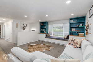 Living room featuring recessed lighting, carpet flooring, a textured ceiling, and built in features