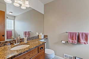 Half bath with vanity and a textured ceiling