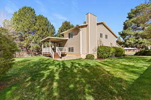 View of side of property with a chimney and a deck