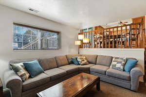 Living room featuring a textured ceiling and ceiling fan