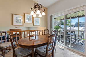 Dining space with vaulted ceiling, hanging lights, and light tile patterned floors