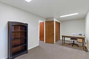 Office with light colored carpet and baseboards