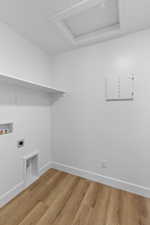 Laundry area featuring light wood-style flooring, hookup for a washing machine, and hookup for an electric dryer