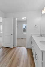 Bathroom with double vanity and light wood-style floors
