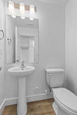 Bathroom featuring wood finished floors and toilet