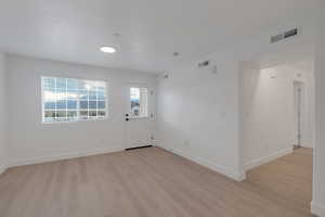 Entrance foyer with baseboards and light wood finished floors