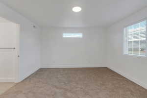 Spare room featuring healthy amount of natural light and light colored carpet