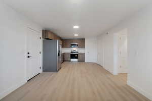 Kitchen with stainless steel appliances, light countertops, light wood-style flooring, modern cabinets, and recessed lighting