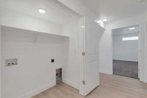 Laundry area with washer hookup, light wood finished floors, and electric dryer hookup