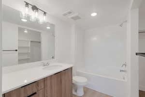 Bathroom featuring vanity, recessed lighting, light wood finished floors, and shower / bath combination