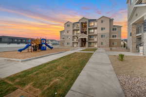 Playground at dusk with a lawn and a residential view
