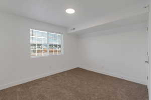 Carpeted empty room featuring baseboards