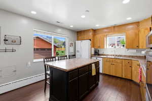 Kitchen with a kitchen island, decorative backsplash, light countertops, dark wood finished floors, and recessed lighting