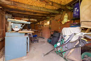 Below grade area with a workshop area and brick wall