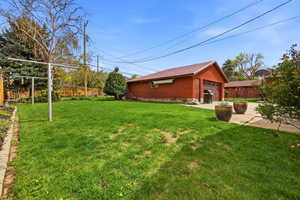 View of side of home with an outbuilding, a detached garage, and a patio