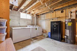 Laundry area with concrete flooring, gas water heater, and separate washer and dryer