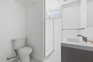 Full bathroom featuring vanity, a shower stall, and light tile patterned floors