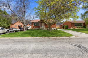 View of front of home with a front yard and brick siding