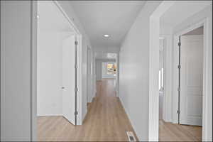 Hallway featuring light wood-type flooring and recessed lighting