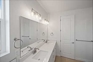 Bathroom with double vanity and baseboards