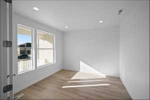Empty room featuring light wood finished floors and recessed lighting