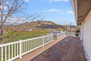 Deck with a mountain view and a lawn