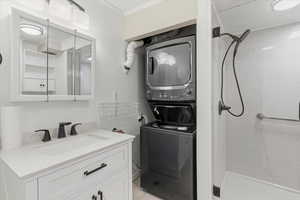 Laundry area with stacked washing machine and dryer and ornamental molding