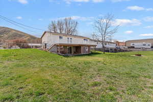 Back of house featuring a fenced backyard, a patio area, and a deck with mountain view