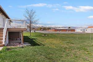 Fenced backyard with stairs and a deck with mountain view