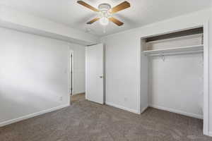 Unfurnished bedroom featuring carpet flooring, a closet, ceiling fan, and a textured ceiling
