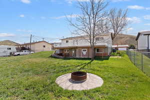 Back of property featuring a fire pit, a patio area, and a fenced backyard