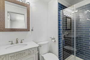 Full bath featuring ornamental molding, vanity, and a shower stall