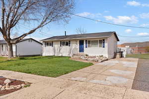 View of front of house featuring a front lawn, driveway, and roof with shingles