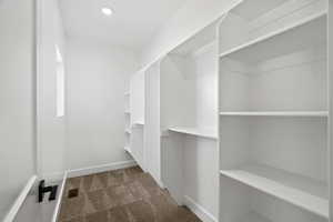 Walk in closet with dark carpet