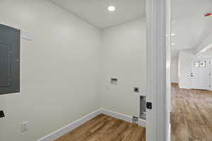 Laundry area featuring light wood-style floors, recessed lighting, electric panel, washer hookup, and hookup for an electric dryer