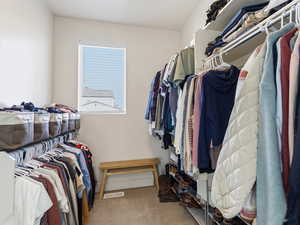 Walk in closet featuring light colored carpet