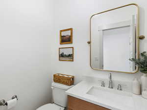 Half bath featuring toilet and vanity