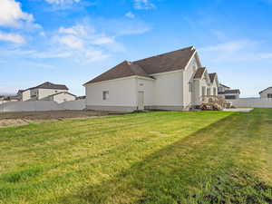 Rear view of house with stucco siding and roof with shingles
