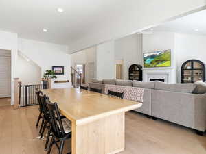 Kitchen featuring a breakfast bar area, a brick fireplace, light wood-style flooring, recessed lighting, and open floor plan