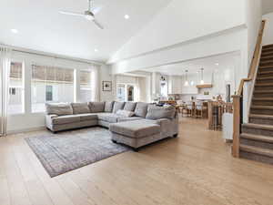 Living area featuring ceiling fan, recessed lighting, vaulted ceiling, and light wood-style flooring