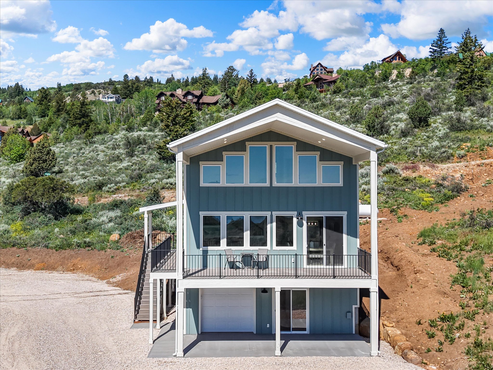 Modern-style residence featuring a blue vertical siding exterior and a white trim roofline