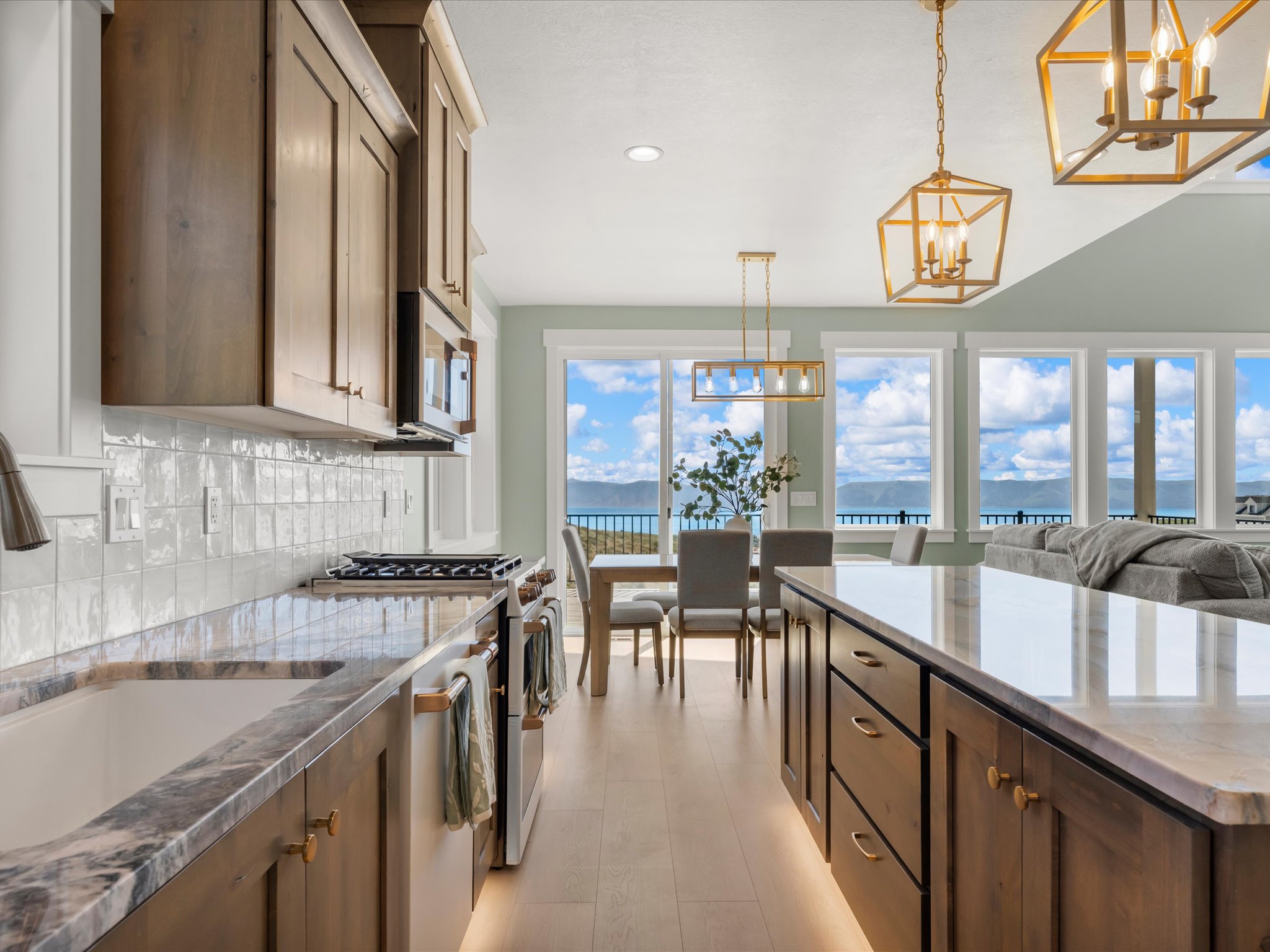 Gourmet kitchen featuring wood-finish cabinetry, stone countertops, and a subway tile backsplash