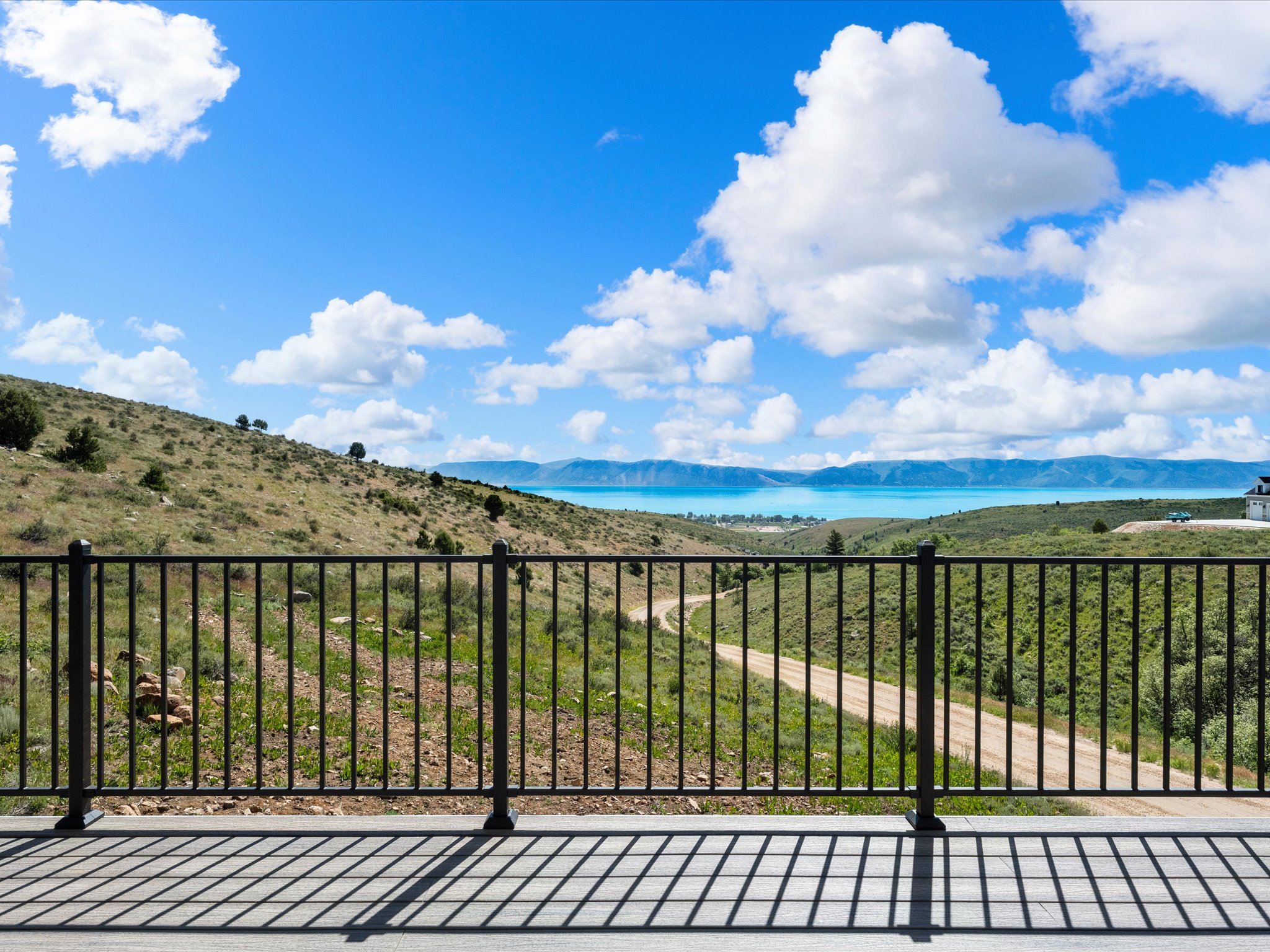 Outdoor deck featuring a black metal railing and expansive distant water