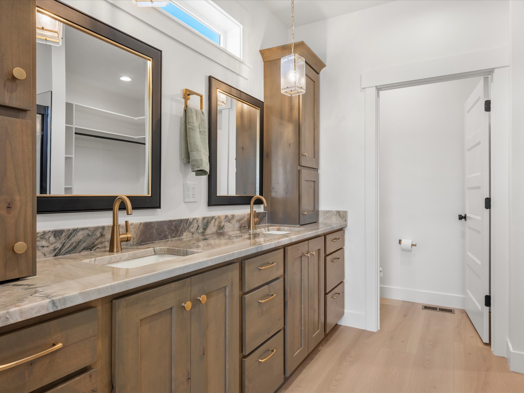Dual vanity with wood-finish cabinetry and brass hardware